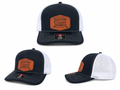 Navy and white trucker hat with South Coast logo patch, mesh back, curved brim