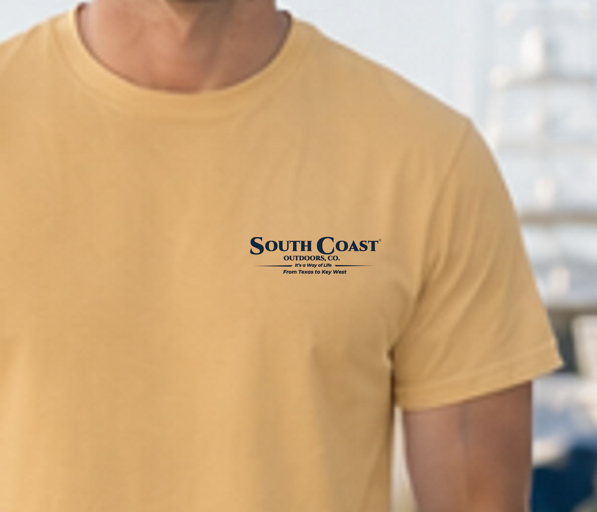 Tan t-shirt chest logo with South Coast Outdoors Co and sea trout icon.
