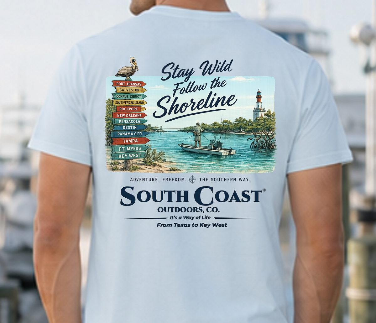 Light blue T-shirt back with “Stay Wild” shoreline and lighthouse graphic