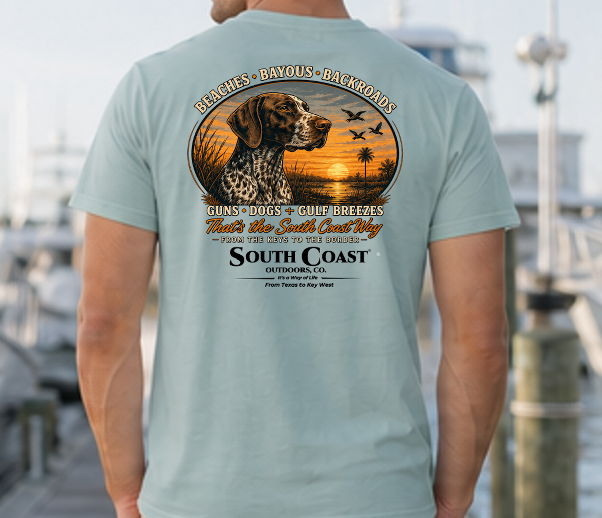 Teal T-shirt with circular animal sunset graphic and “South Coast Outdoors” back print