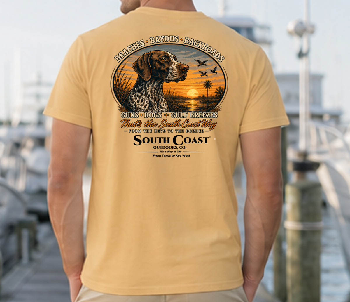 Tan T-shirt with circular animal sunset graphic and “South Coast Outdoors” back print