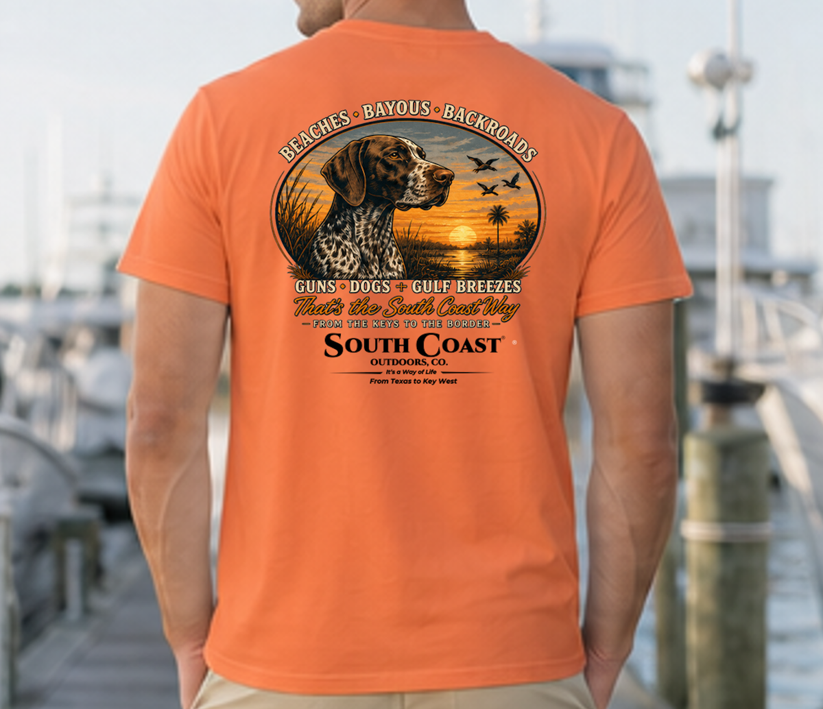 Orange T-shirt with circular animal beach graphic and “South Coast Outdoors” back print