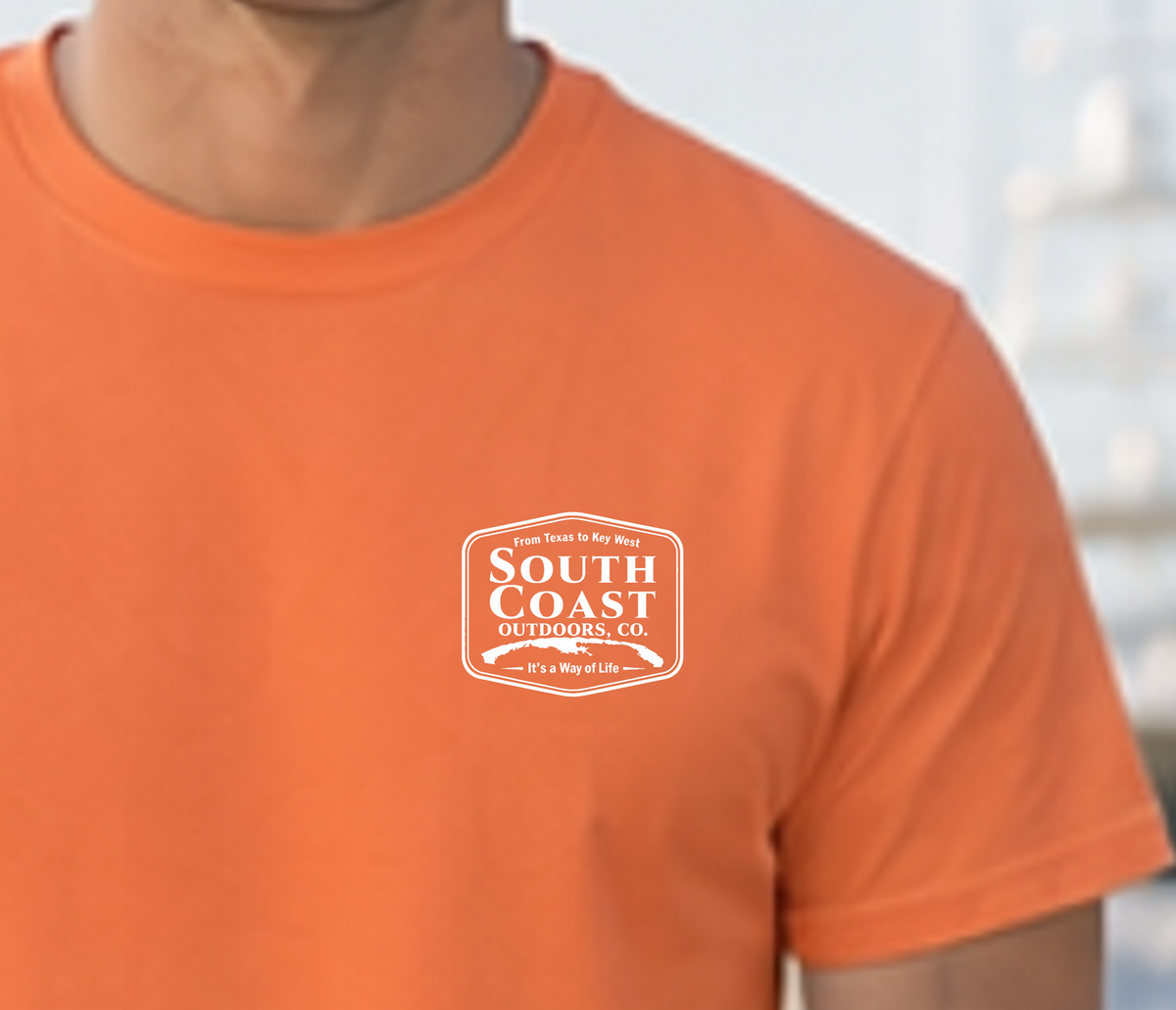 Orange short-sleeve T-shirt with small white South Coast Outdoors logo badge on chest.